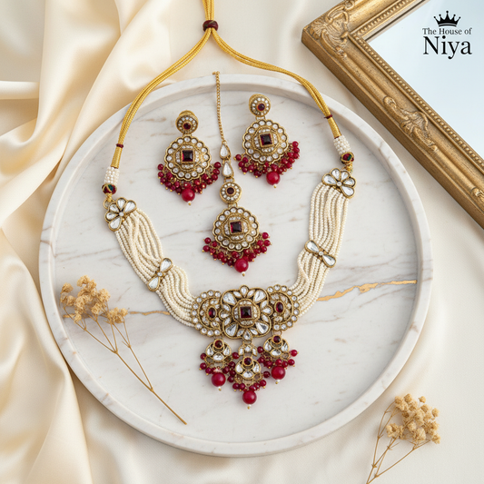 Ruby red polki pearl necklace, chandbali earrings and tikka set on marble tray