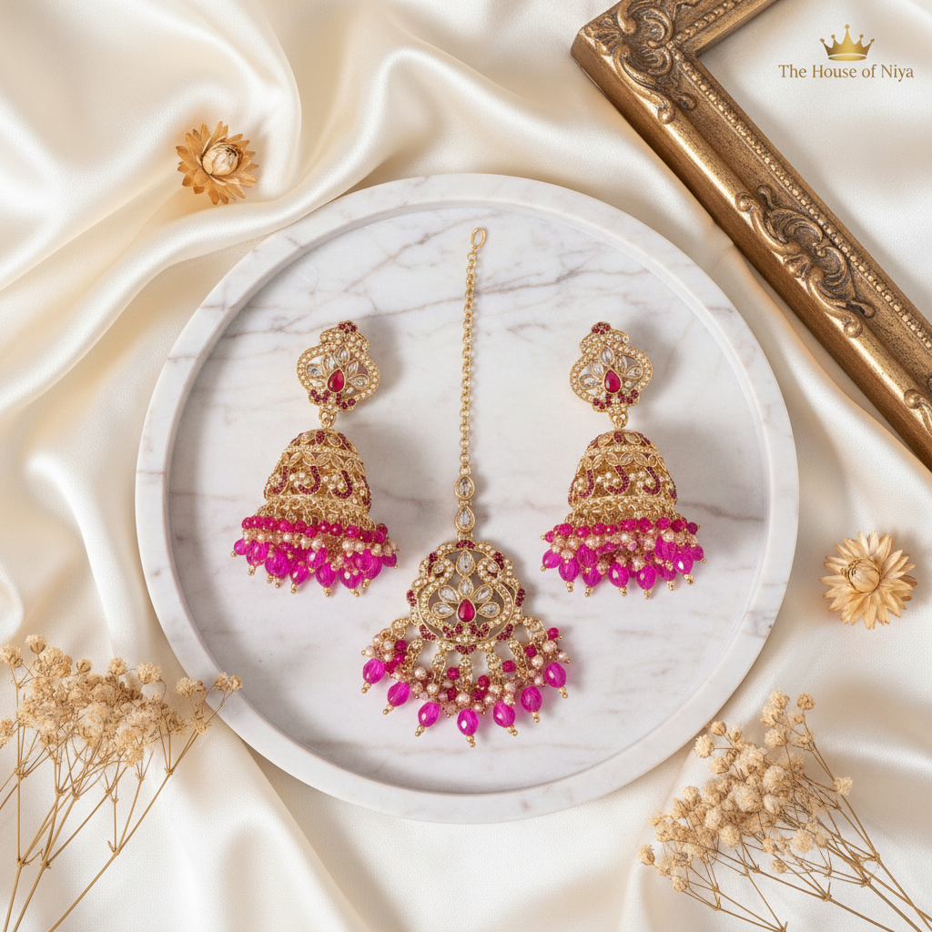 Hot pink jhumka earrings and tikka set on marble tray
